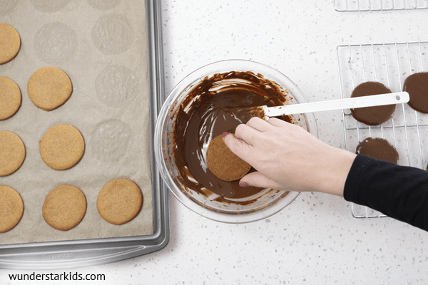Dipping moon pie crust in chocolate