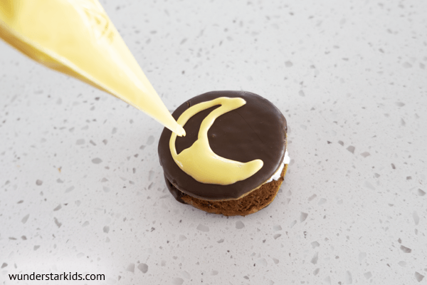 Decorating moon pie with icing